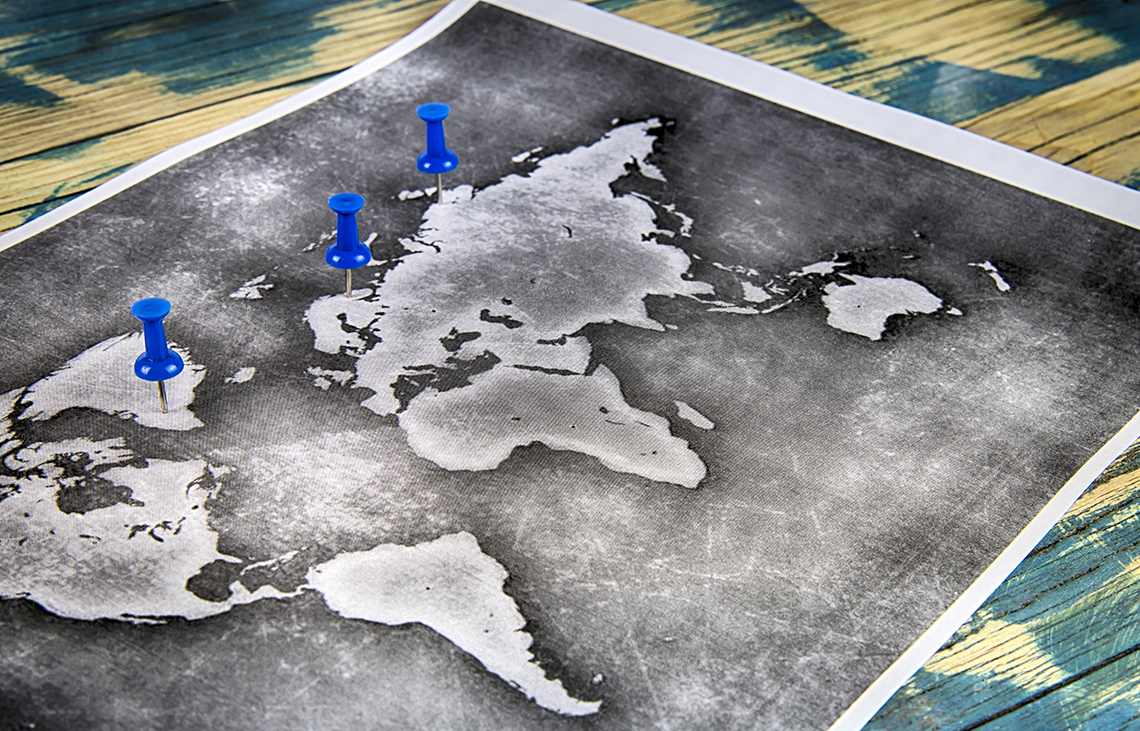 Image of a world map with push pins in different countries